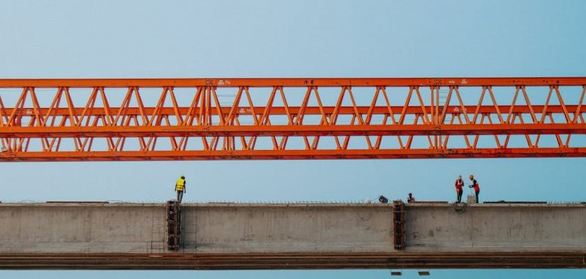 Alloy Development - Construction workers on a bridge with a crane