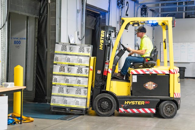 man-riding-a-yellow-forklift-lifting-boxes